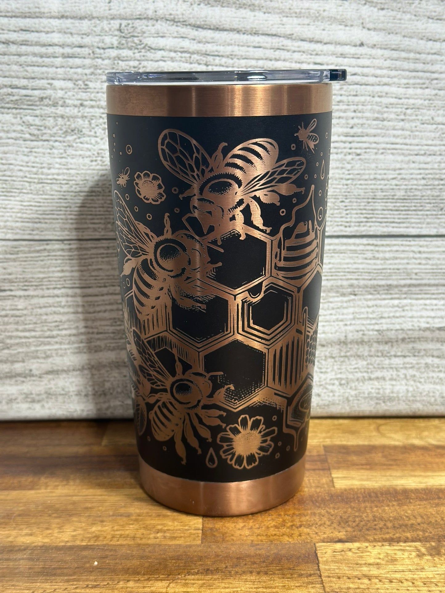 Custom designed bee tumbler with copper accents, featuring an intricate bee and honeycomb pattern.